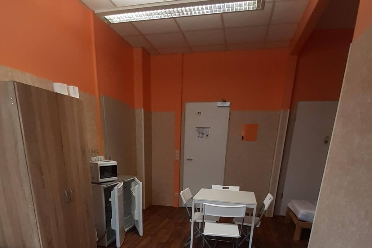 A room with two beds, a desk, and a chair.