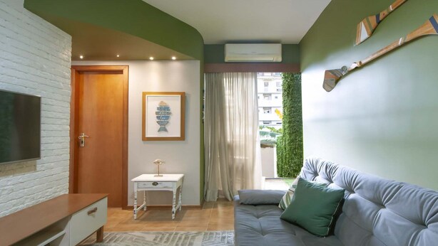 Un salon avec un téléviseur, un canapé, une petite table et une porte.