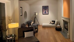 A cozy living room with a fireplace, a sofa, a coffee table, and a lamp. - Spacious 5-bedroom villa with beautiful panoramic view!! (Buskerud)