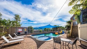 A pool area with lounge chairs, a small pool, and a covered seating area. - Airlie Beach main street 2 minute walk (Airlie Beach)