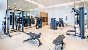 A modern gym with various exercise equipment, mirrored walls, and a clean, spacious layout. - StayShort - Stylish JBR Apartment Sleeps 4 with Marina Views (JBR)