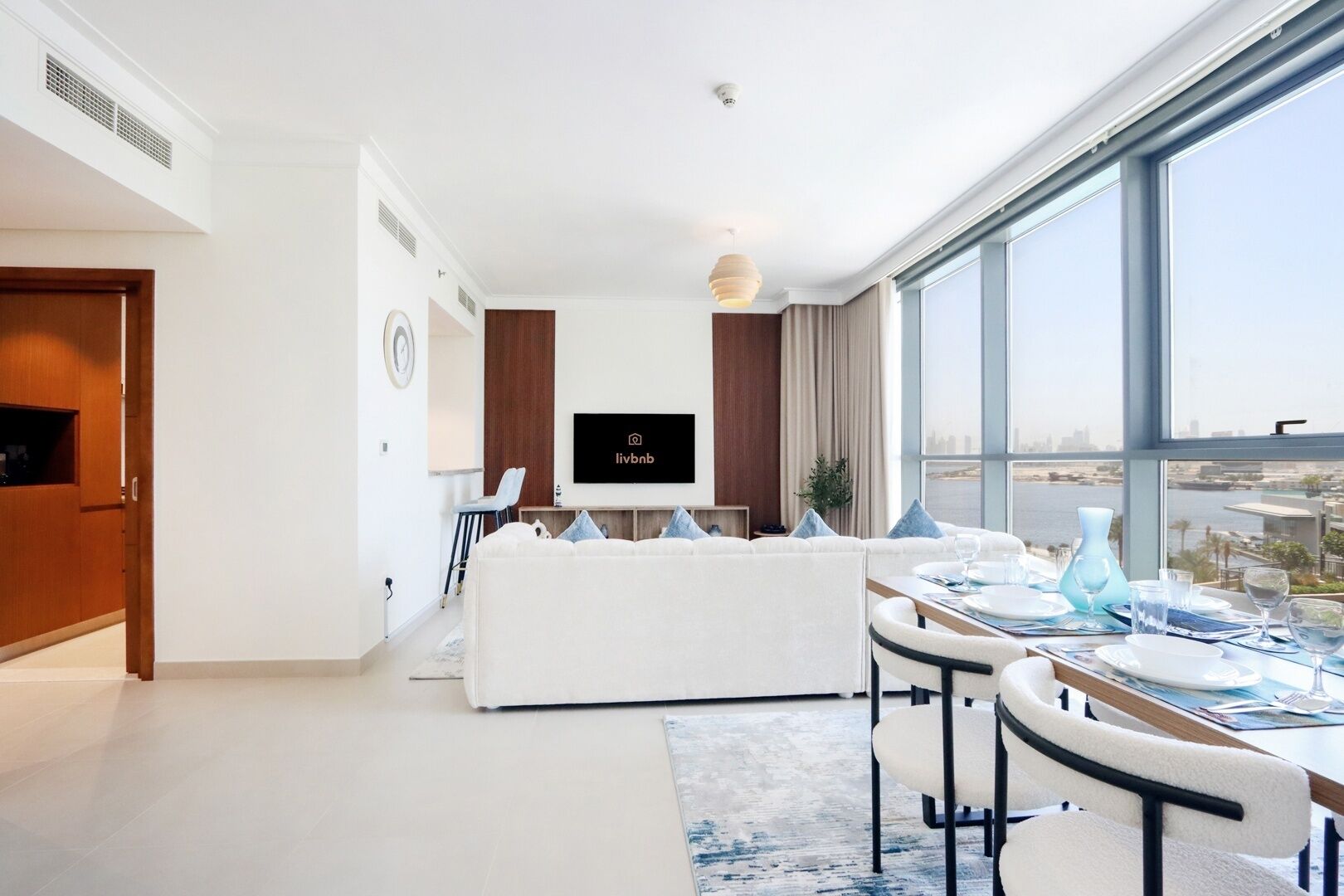 A modern living room with a sofa, dining table, and TV.