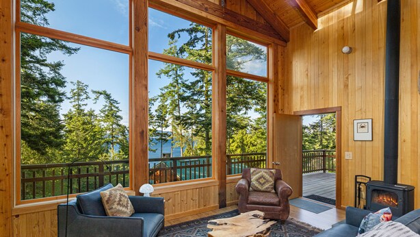 A spacious room with large windows, a fireplace, and a cozy seating area.
