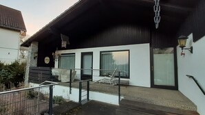 A modern building with a flat roof, large windows, and a balcony with metal railings. - Holiday Home 'With Pool Hall' with Private Terrace, Garden and Wi-Fi (Burgthann)