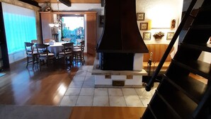 A spacious living area with a fireplace, wooden flooring, and a staircase. - Holiday Home 'With Pool Hall' with Private Terrace, Garden and Wi-Fi (Burgthann)