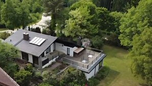 A modern house with a flat roof, solar panels, and a large garden. - Holiday Home 'With Pool Hall' with Private Terrace, Garden and Wi-Fi (Burgthann)