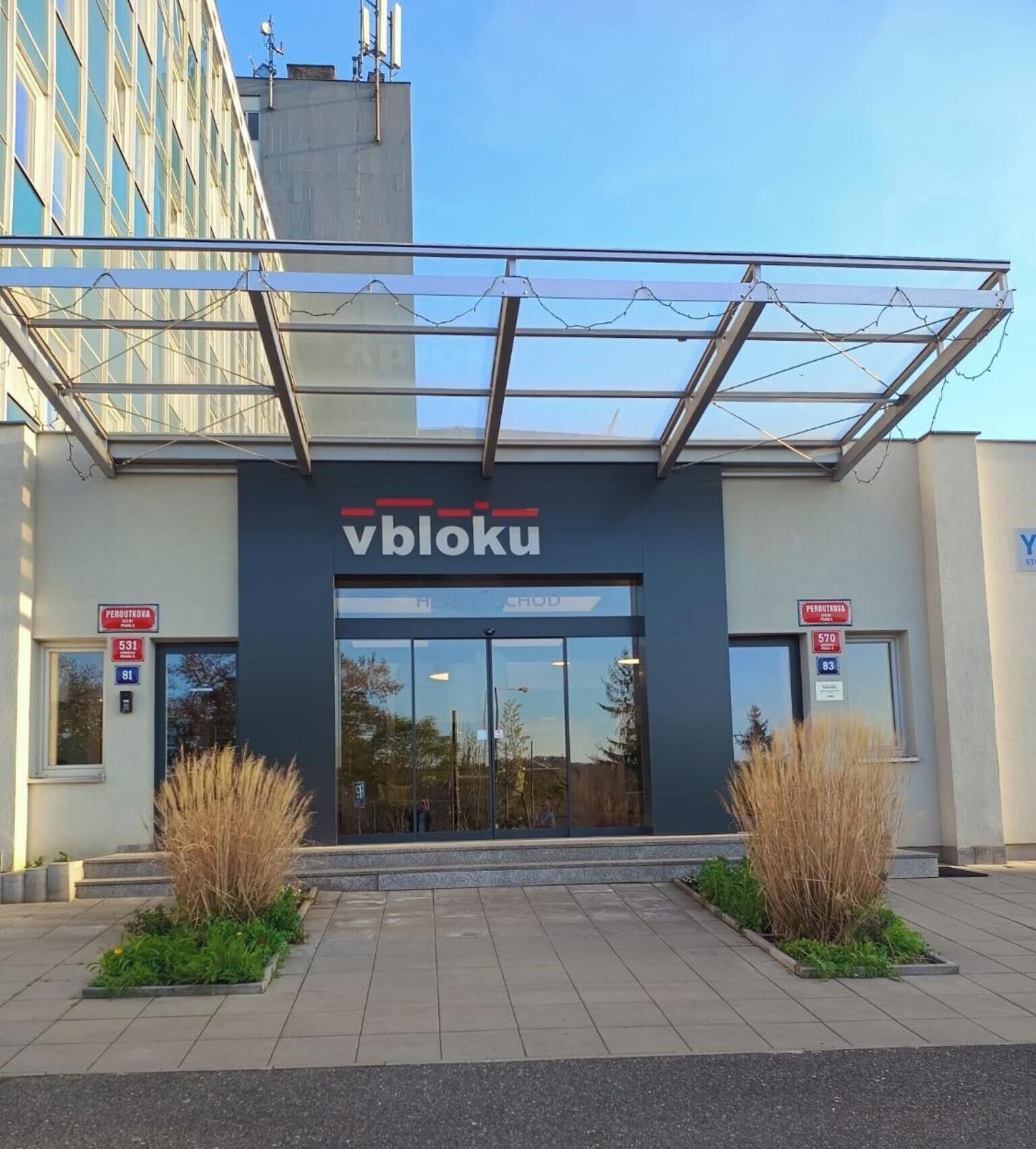 En modern byggnad med en entré av glas och namnet ”vbloku” tydligt synligt.