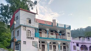 Un hotel de varios pisos con balcones, un cartel de Coca-Cola y un anuncio de 'Religious Burger'.