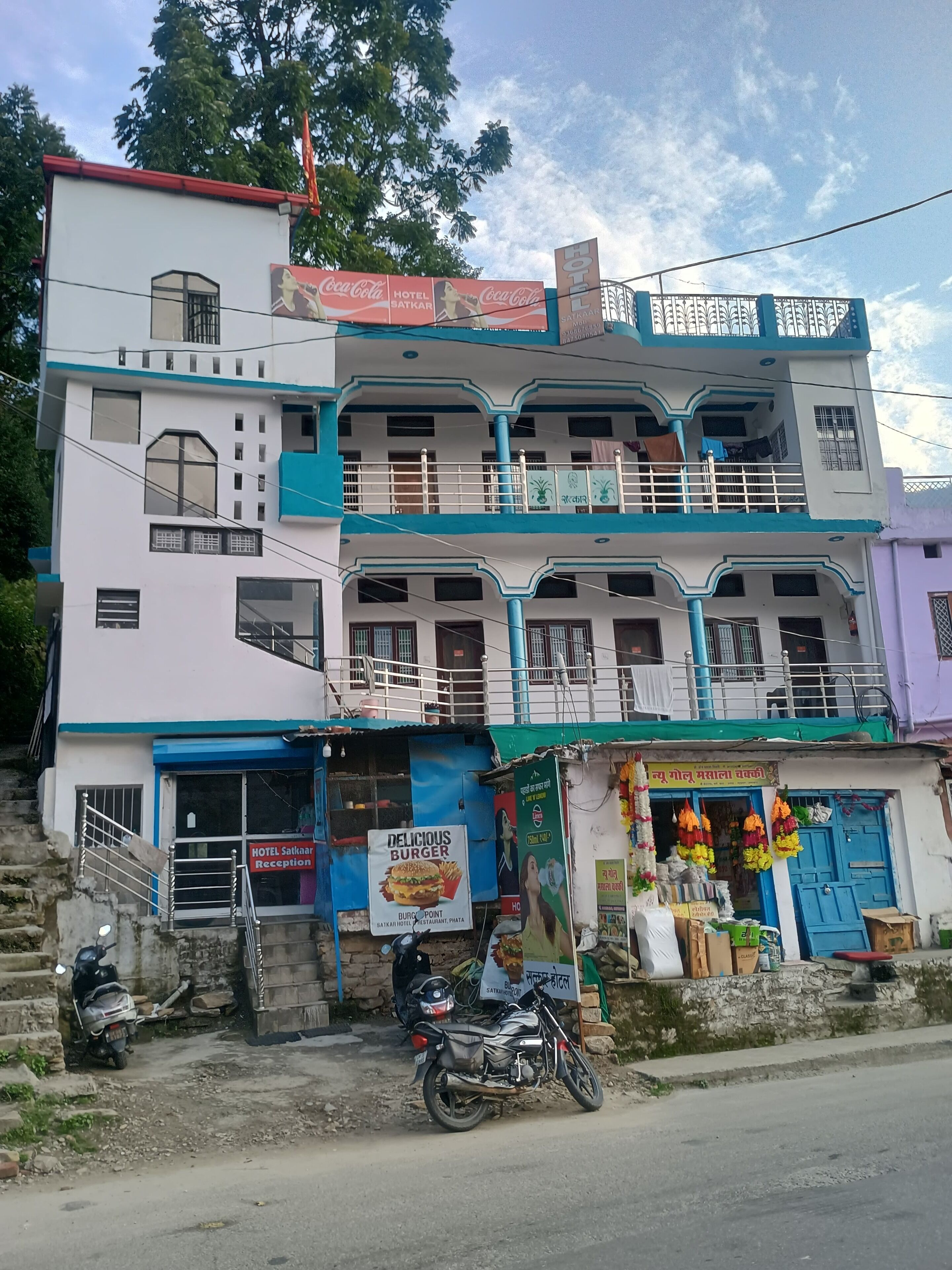A multi-story building with a reception area, a sign for a burger restaurant, and a shop with colorful flowers.