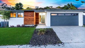 A modern two-story house with a garage, a well-maintained lawn, and a driveway.