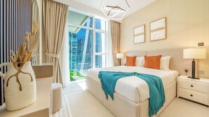 Ein modernes Hotelzimmer mit einem großen Bett, Nachttischen, einem Schreibtisch und Blick auf die Stadt.