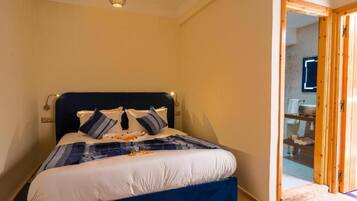 Un dormitorio con cama, una puerta de madera y una lámpara en el techo.