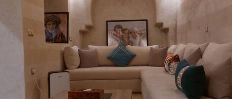 A living room with a sofa, a coffee table, and a TV.