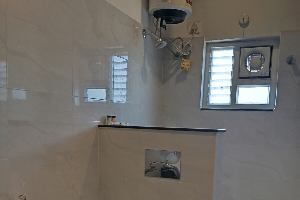 Une salle de bain moderne équipée de toilettes, d’une douche et d’une fenêtre.