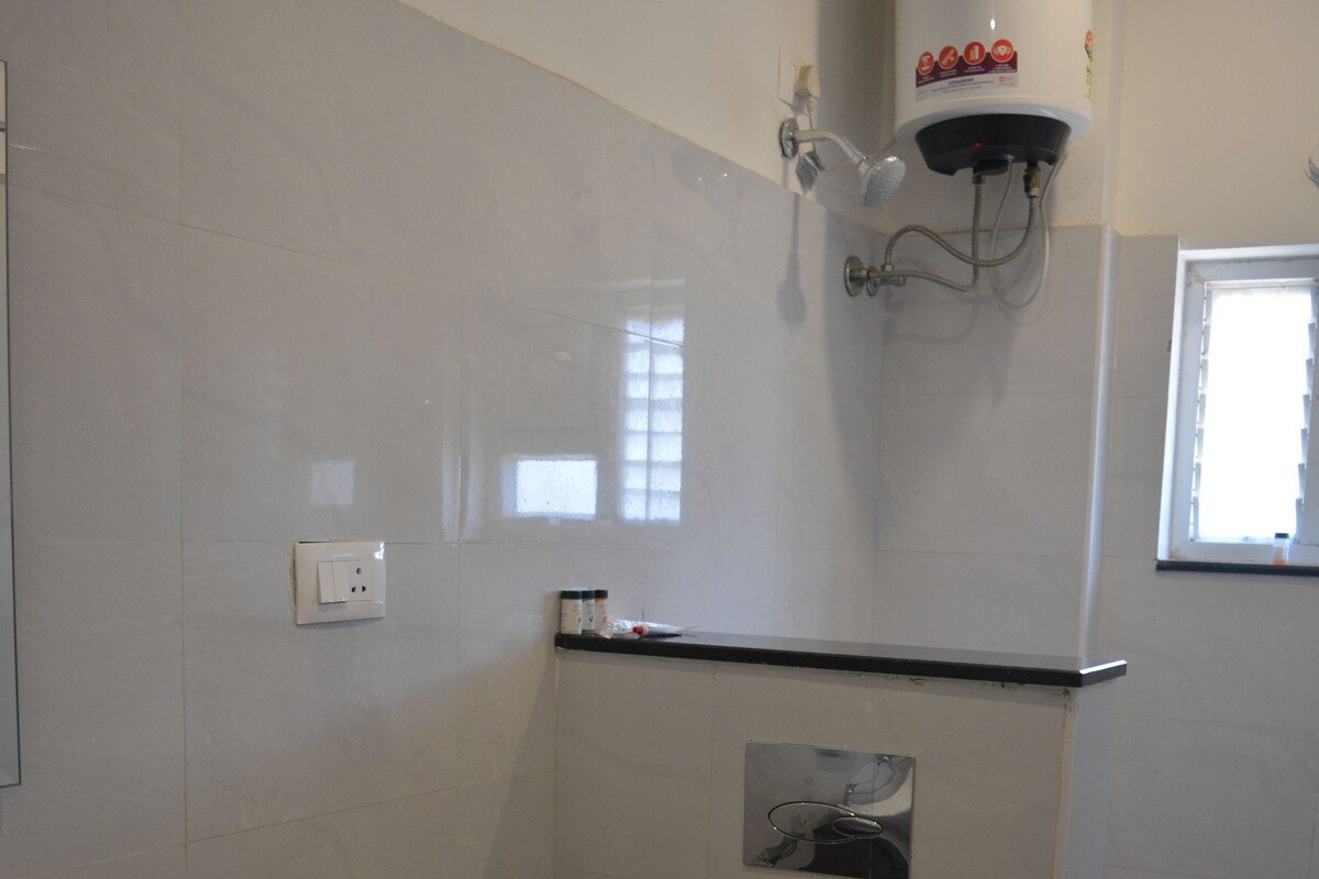 A bathroom with a toilet, sink, and a water heater.