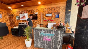 A reception desk with a neon sign reading "Hervey's Lounge" in a room with wooden walls and a marble counter. - Heavens View Resort (Mussoorie)