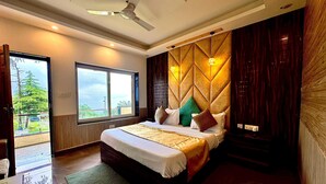 A bedroom with a bed, a ceiling fan, a window, and a view of greenery outside. - Heavens View Resort (Mussoorie)