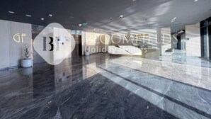 Un hall d’entrée spacieux, doté d’un sol en marbre poli, d’un comptoir de réception et d’un design moderne.