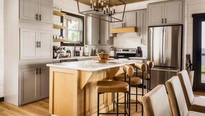 A modern kitchen with a large island, stainless steel appliances, and wooden accents. - Incredible 180 VIEWS! | Luxury Lodge | Indoor Pool (Sevierville)