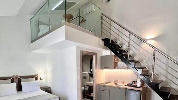 Un appartamento moderno con camera soppalco, cucina e scala.