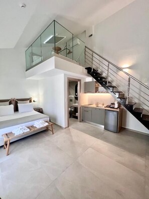 Um apartamento moderno com quarto no mezanino, cozinha e escada.