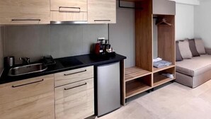 Una cucina moderna con mobili chiari in legno, un piano di lavoro nero e una lavastoviglie integrata.