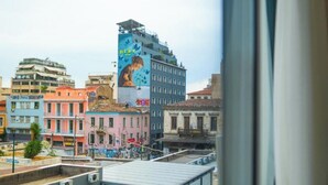 A cityscape with colorful buildings, including a prominent mural on a building. - Sani Deluxe Suite Home (Athens)