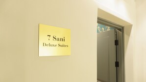 A sign indicating "7 Sani Deluxe Suites" on a wall. - Sani Deluxe Suite Home (Athens)