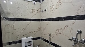 Un baño con inodoro, ducha y un balde.