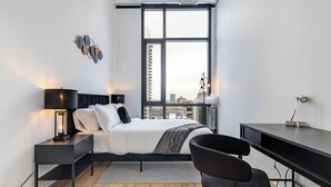 A modern bedroom with a bed, bedside tables, a desk, and a chair. - South Loop Rooftop With In and Out Parking 3 (Chicago)