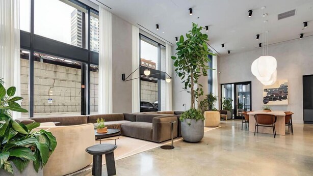 A spacious lobby with a sectional sofa, a dining area, and large windows. - South Loop Rooftop With In and Out Parking 3 (Chicago)
