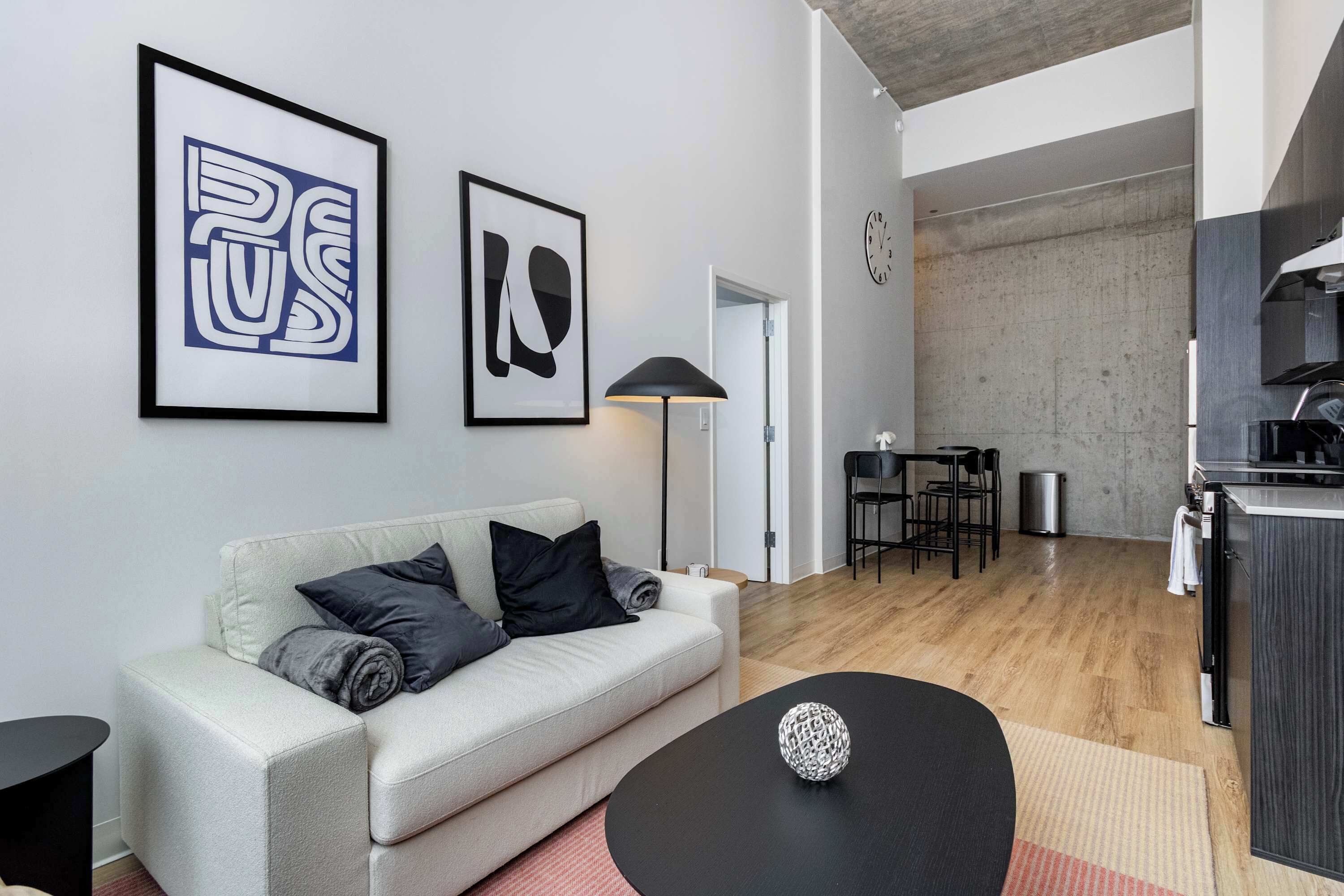 Ein modernes Wohnzimmer mit einer Couch, einem Couchtisch und Kunstwerken an der Wand.
