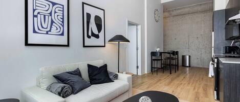 Ein modernes Wohnzimmer mit einer Couch, einem Couchtisch und Kunstwerken an der Wand.