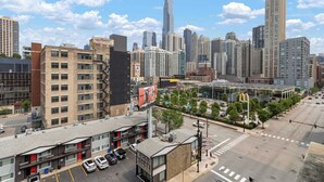 A high-rise building with a modern design, surrounded by other tall buildings. - River North Private Deck With In and Out Parking (Chicago)