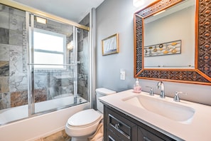 A bathroom with a glass-enclosed shower, a white toilet, a sink with a mirror, and decorative tiles. - Near Dtwn Somerset: Tranquil Getaway w/ Fire Pit (Somerset)