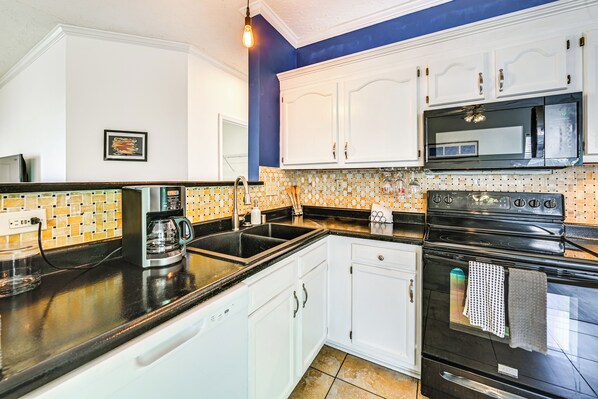 A kitchen with white cabinets, a black stove, and a tiled backsplash. - 10 Mi to Keeneland: Family Home w/ Deck & Yard (Lexington)