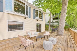 A wooden deck with wicker furniture, a dining table, and a large tree. - Dock + Views: Scenic Lakefront Escape in Harrison (Harrison)