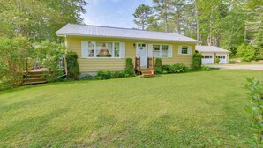 A single-story house with a front porch, a garage, and a well-maintained lawn. - 1 Mi to Main St: Charming Elsworth Home w/ Yard! (Ellsworth)