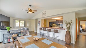 A modern kitchen with a central island, bar stools, and a dining area with a wooden table and chairs. - Hike, Fish, Ski & Explore: Cabin Near Breckenridge (Alma)