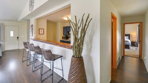 A kitchen with a bar area, a dining table with chairs, and a vase with branches. - Hike, Fish, Ski & Explore: Cabin Near Breckenridge (Alma)
