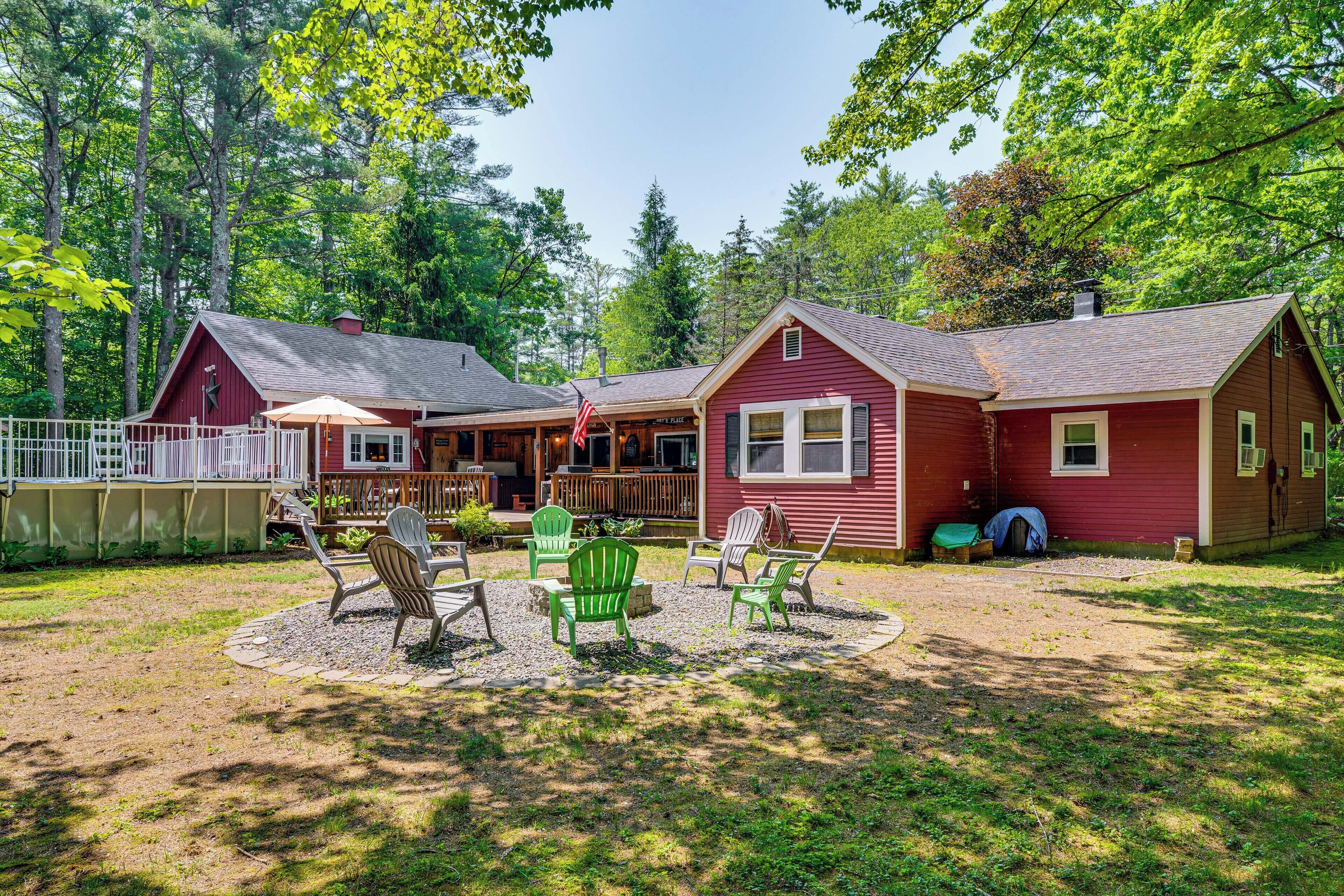 A red cabin with a porch and outdoor seating area.