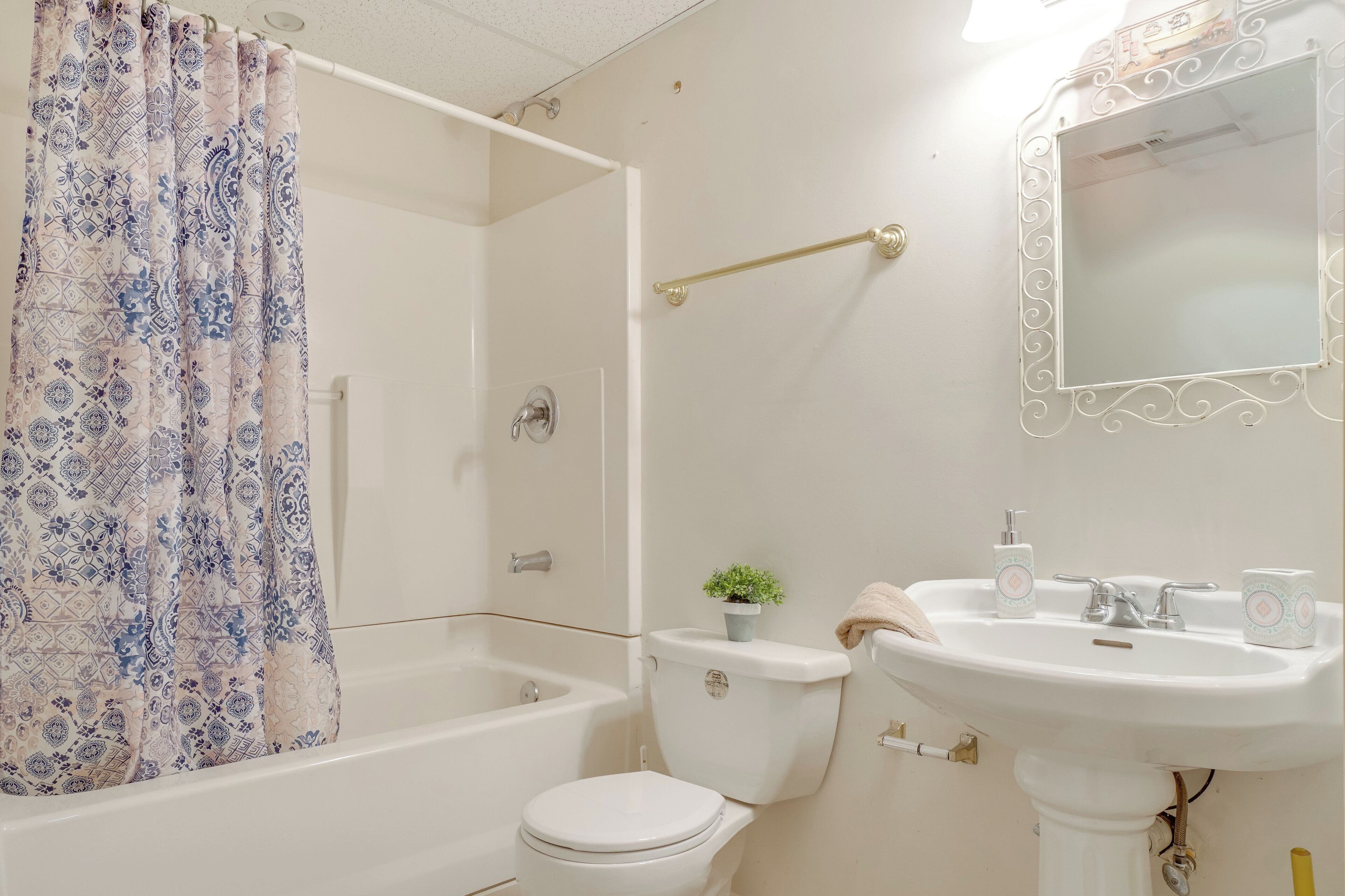 Un baño con bañera, inodoro, lavabo y espejo.