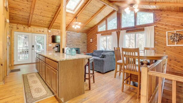 A wooden cabin interior with a kitchen, dining area, and living room. - Private Hot Tub & Game Room: Cleveland Getaway (Cleveland)