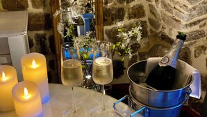 Una mesa con velas, copas de champán y una botella de champán en un cubo.