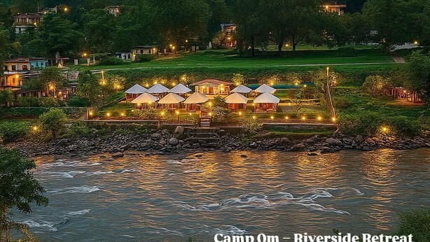A riverside retreat with multiple huts, a river, and a forested backdrop. - Camp OM Riverside Retreat (Pokhri)
