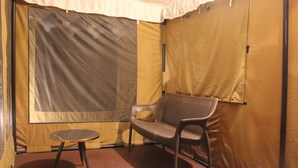 A tented room with a single chair and a small table. - Camp OM Riverside Retreat (Pokhri)