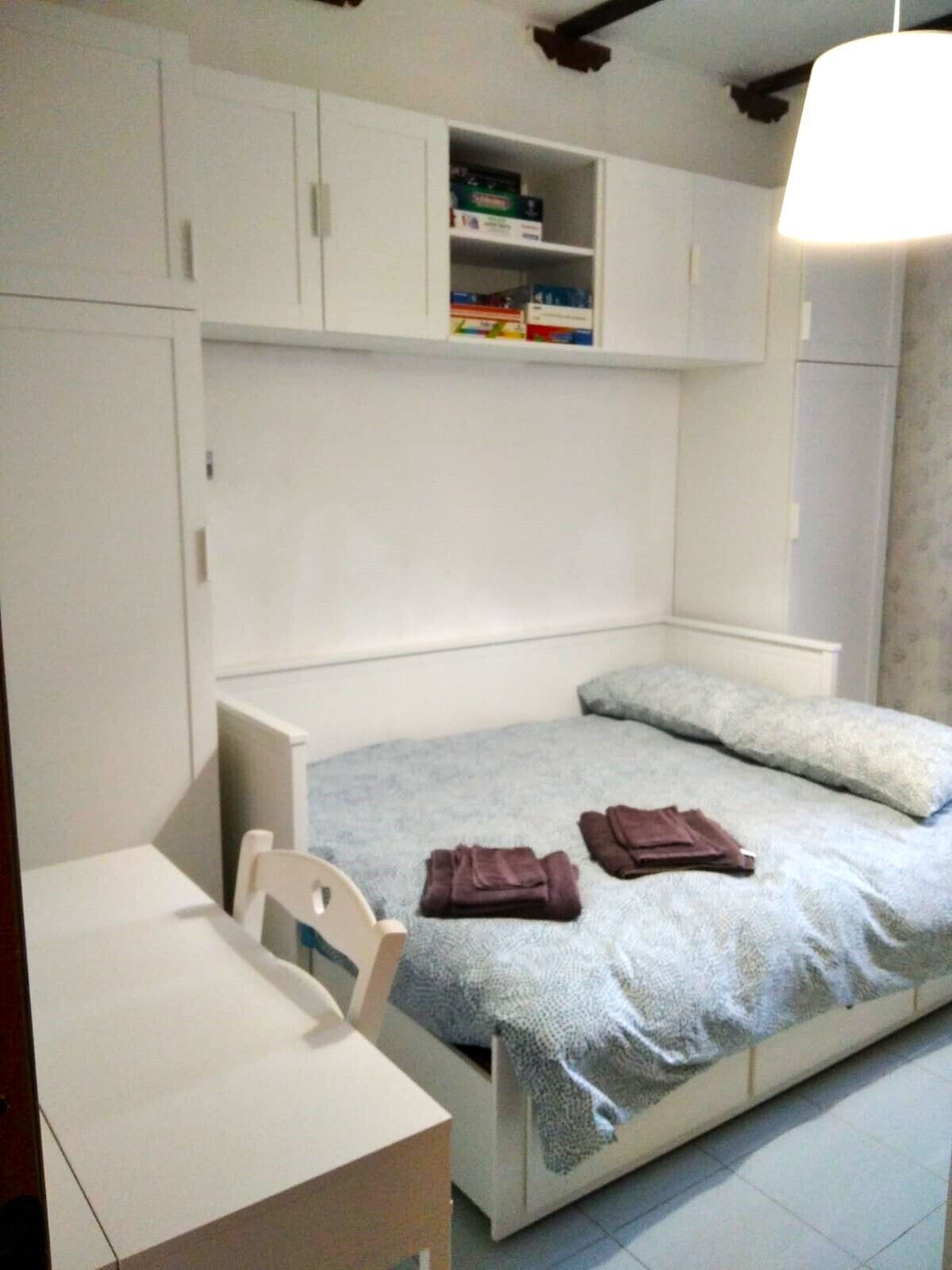 Ein Schlafzimmer mit einem Bett, einem Schreibtisch und einem Kleiderschrank.