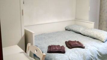Ein Schlafzimmer mit einem Bett, einem Schreibtisch und einem Kleiderschrank.