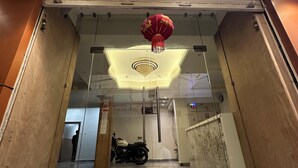 L’entrée d’un hôtel, avec une enseigne indiquant « HÔTEL TEMPLE VIEW », une lanterne rouge et une moto garée à l’intérieur.
