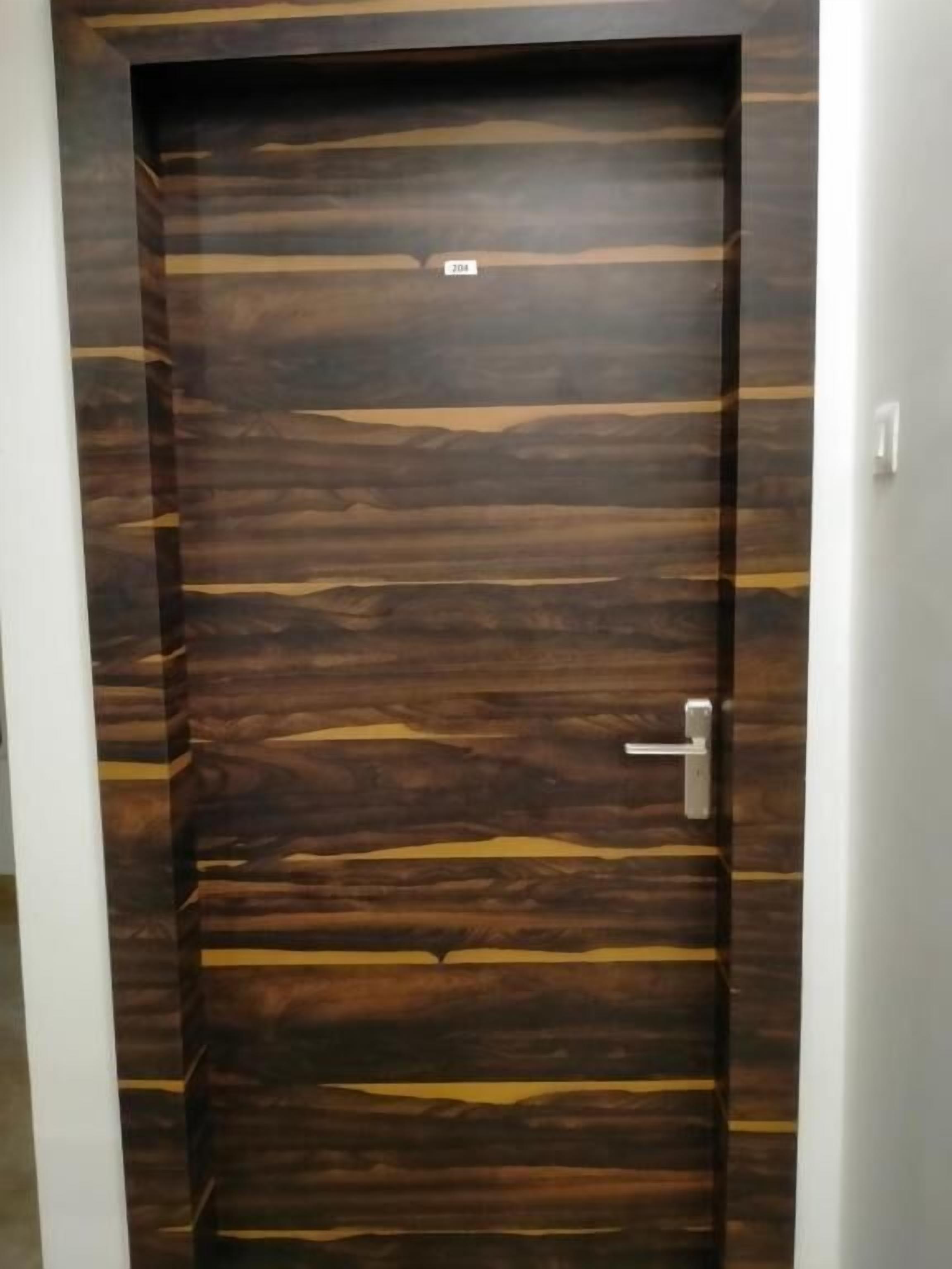 A wooden door with a metal handle and a small label above it.